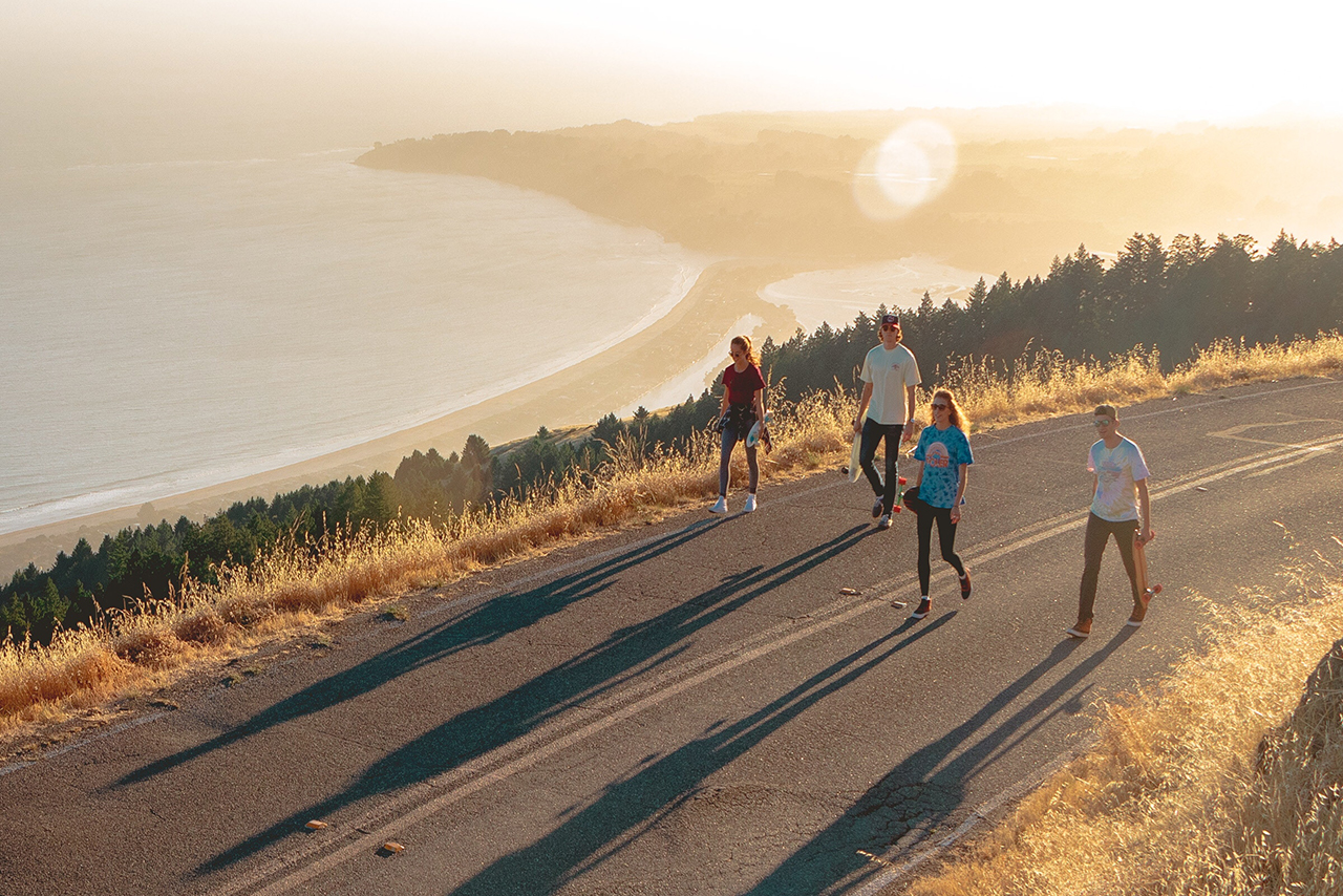 スケボーを持って歩く若者たち